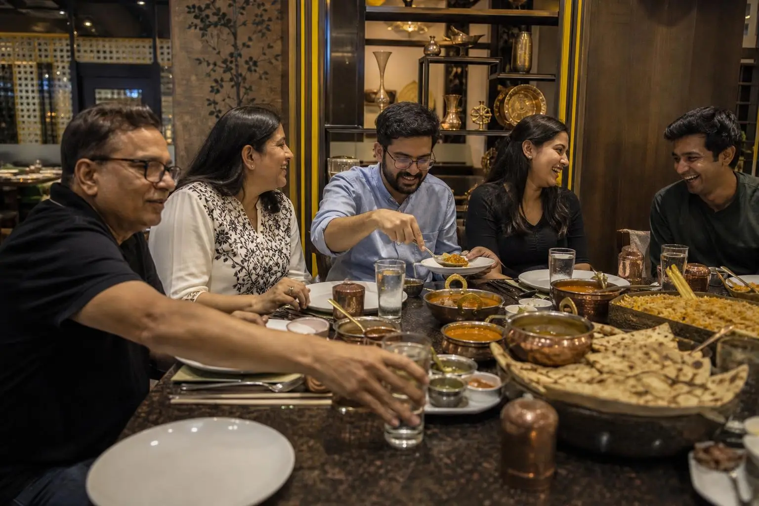 Indian family sharing dishes and conversation at a contemporary restaurant