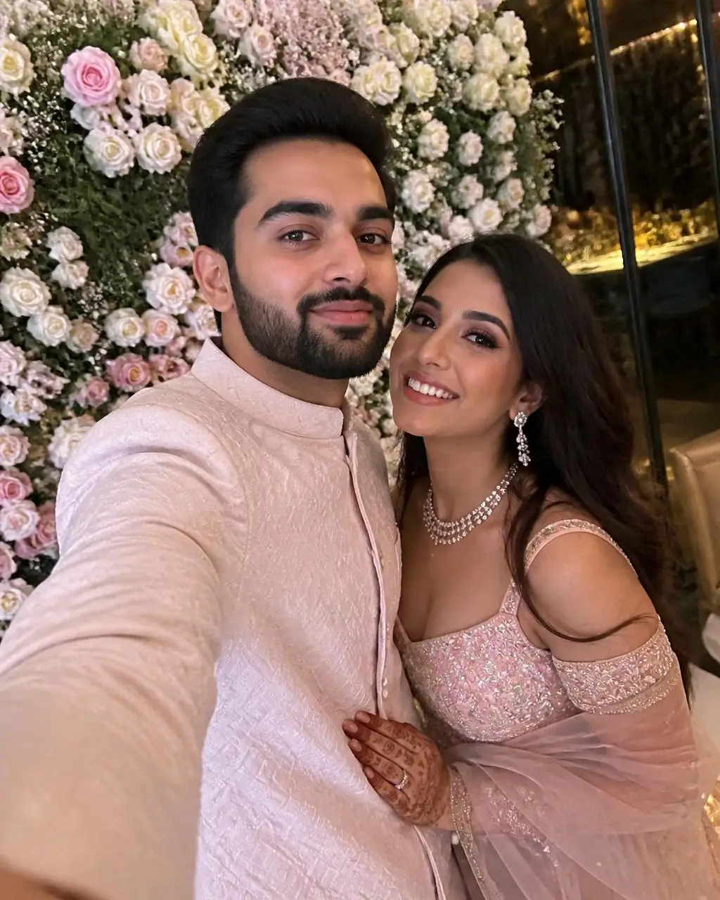 Engagement selfie in front of a floral wall